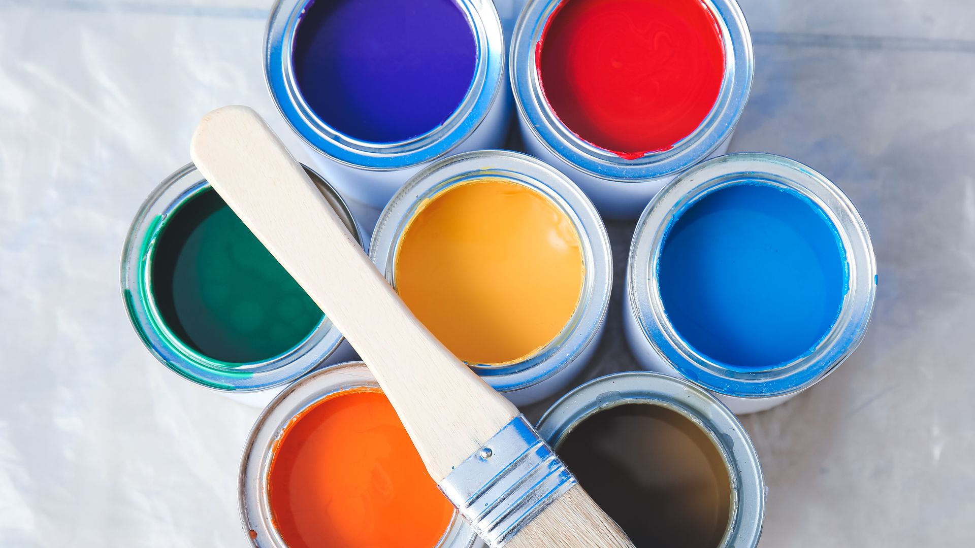 A close up of a paint can with a brush